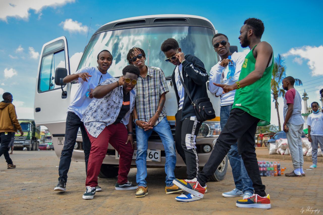 Mentees and a mentor gathered beside their minibus