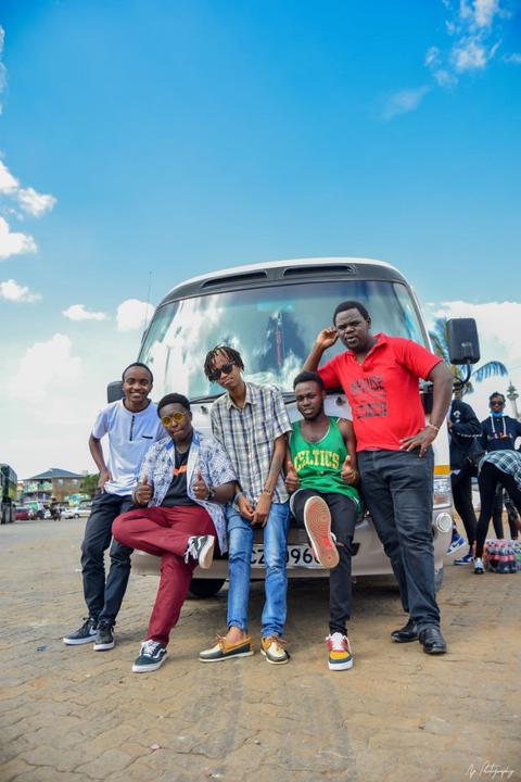 The group sitting together in front of the bus