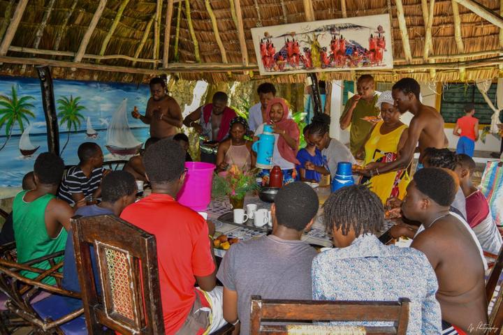 The group seated together inside a thatched dining area