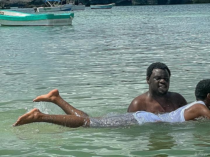 A young man floating in the clear ocean water