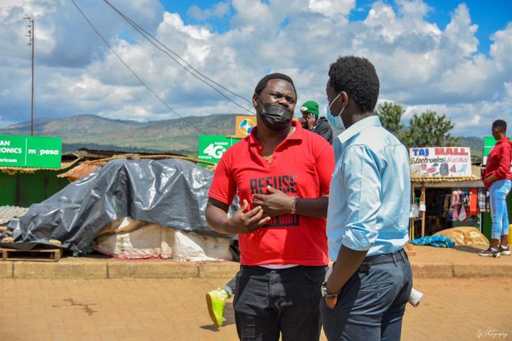Two young men talking at a roadside stop