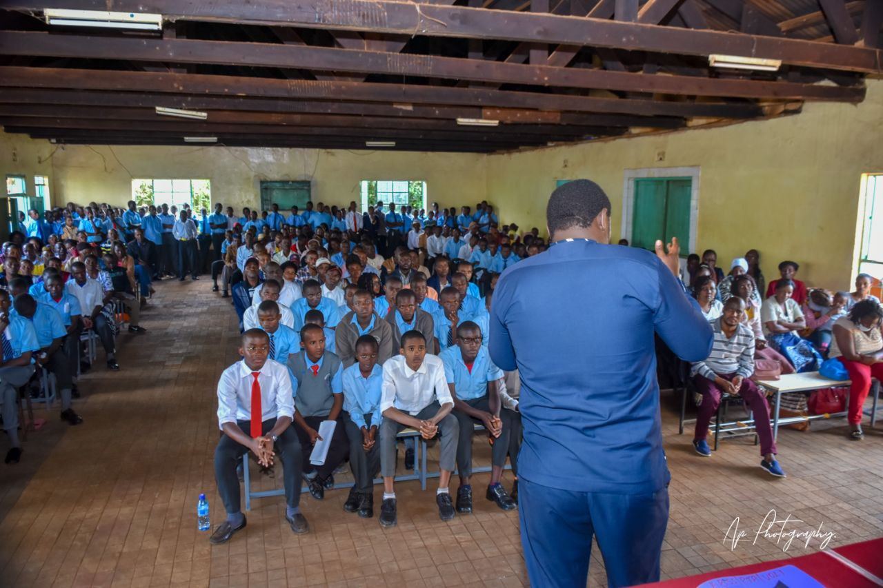 Nelson addressing a large seated school audience