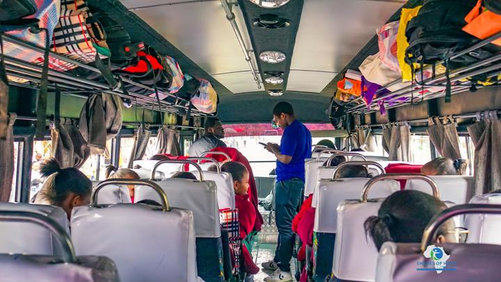 Students seated inside a bus on the way to school