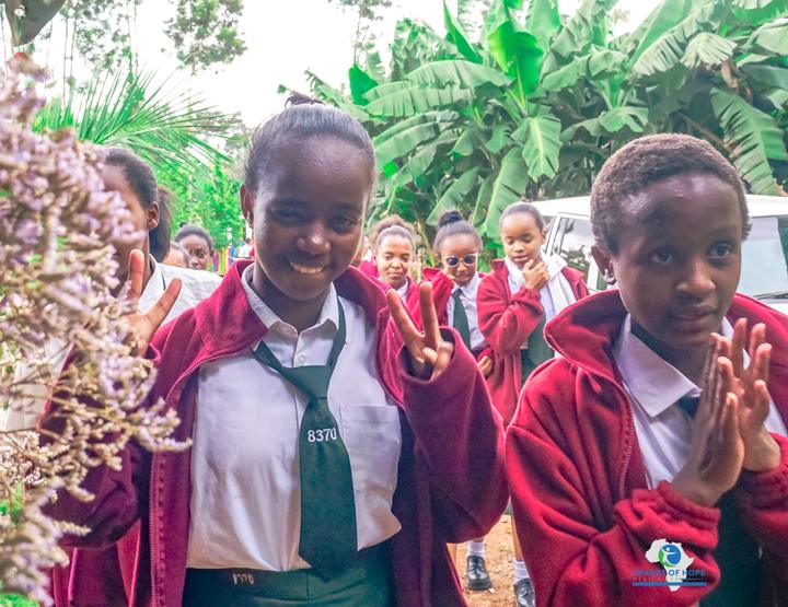 Two students in school uniform smiling outdoors