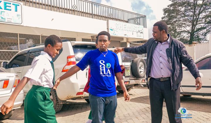 A SOHA team member and a parent with a student at drop-off