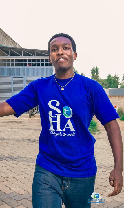 A smiling young man in a SOHA T-shirt